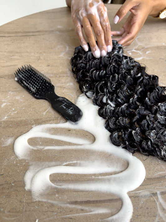 True + Pure Texture Hair Extensions Island Curl Type 3A loose curly wavy bundle being washed shampooed next to True + Pure Texture detangling brush - sensory natural hair visual