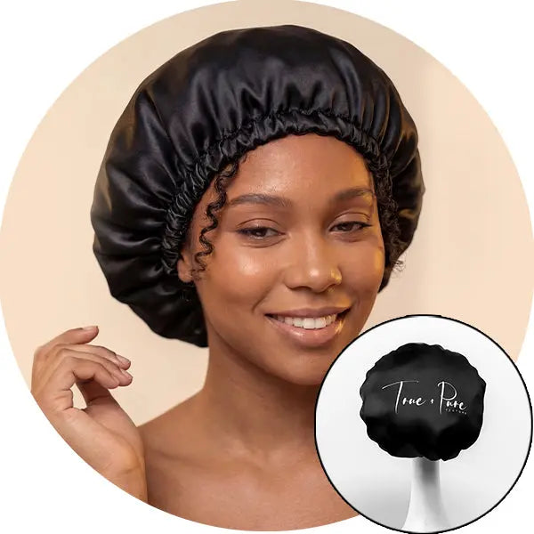 Woman wearing a black satin bonnet with 'True & Pure' logo inset.